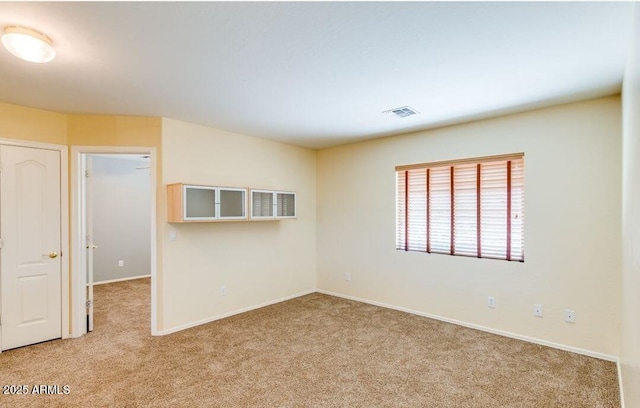 unfurnished room featuring light colored carpet