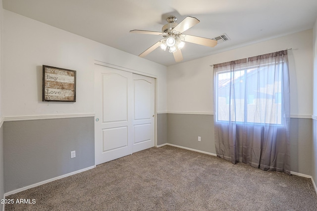 unfurnished bedroom with carpet flooring, ceiling fan, and a closet