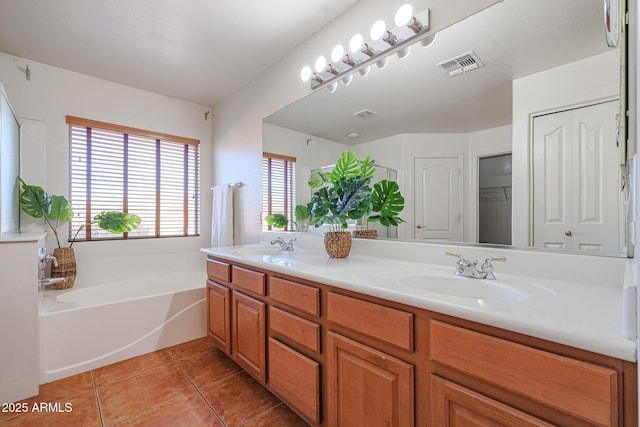 bathroom featuring tile patterned flooring, vanity, and a bath