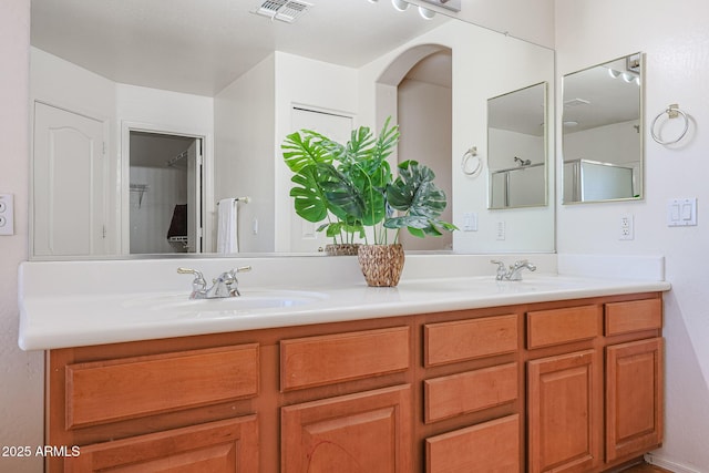 bathroom with vanity and a shower with door