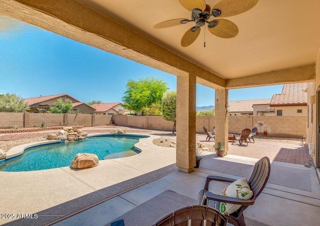 view of pool with pool water feature, ceiling fan, and a patio