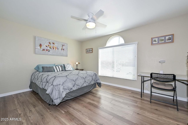 bedroom with a ceiling fan, baseboards, and wood finished floors