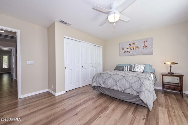 bedroom with ceiling fan, visible vents, baseboards, a closet, and light wood-type flooring