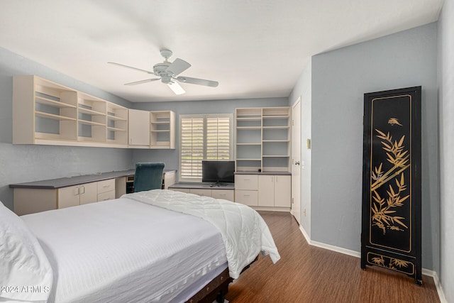 bedroom featuring ceiling fan, dark hardwood / wood-style floors, and built in desk