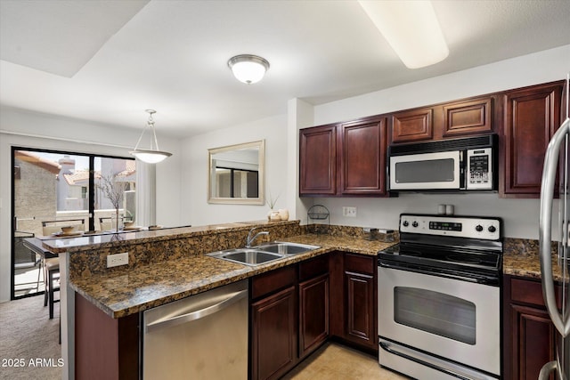 10115 E Mountain View Rd Unit 2061, Scottsdale, AZ 85258 - kitchen with stainless steel appliances, a peninsula, pendant lighting, and dark stone countertops