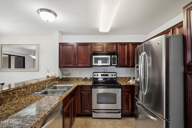 10115 E Mountain View Rd Unit 2061, Scottsdale, AZ 85258 - kitchen with stainless steel appliances, dark stone counters, light tile patterned floors, and reddish brown cabinets