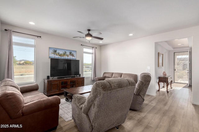 living room with light hardwood / wood-style floors and ceiling fan