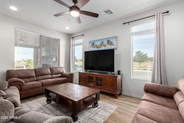 living room with light hardwood / wood-style flooring and ceiling fan