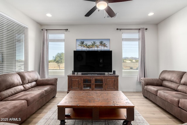 living room with light hardwood / wood-style floors and ceiling fan