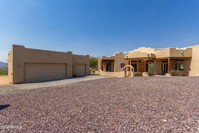 pueblo revival-style home featuring a garage