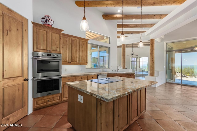 kitchen featuring beam ceiling, ceiling fan, hanging light fixtures, and stainless steel appliances