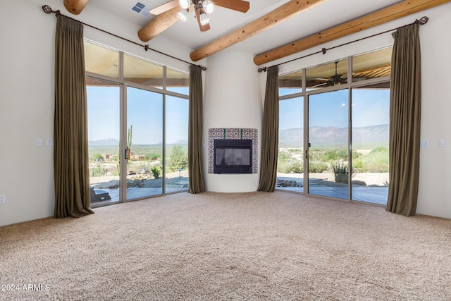 unfurnished living room with a mountain view, a wealth of natural light, carpet floors, and a fireplace