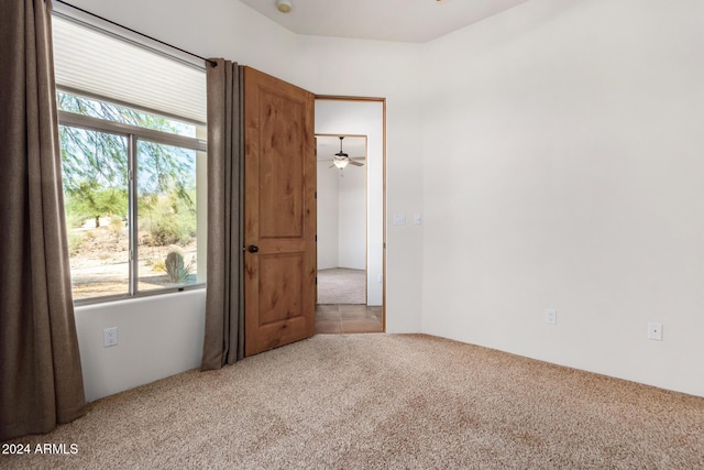 carpeted empty room featuring a wealth of natural light and ceiling fan