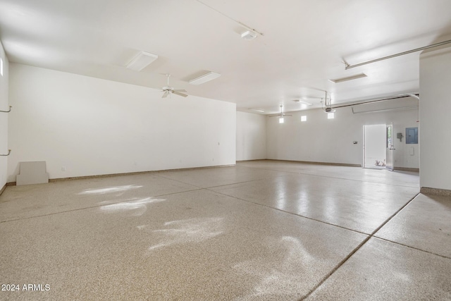 garage featuring electric panel, ceiling fan, and a garage door opener