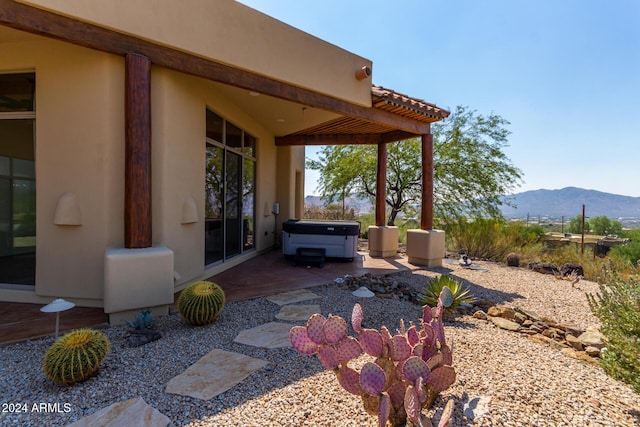 view of patio featuring a mountain view and a hot tub