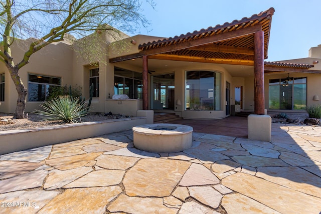 back of property featuring an outdoor fire pit and a patio area