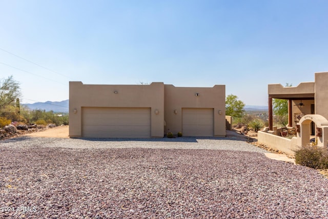 adobe home featuring a mountain view and a garage