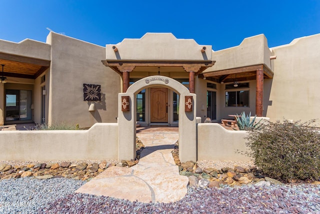 view of exterior entry with ceiling fan