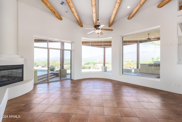 unfurnished living room with ceiling fan, a fireplace, a mountain view, and tile patterned flooring