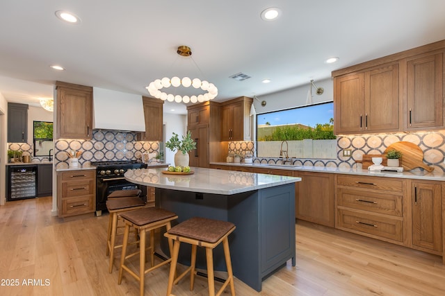 7328 E Laredo Ln, Scottsdale, AZ 85250 - kitchen with high end stainless steel range, wine cooler, custom range hood, decorative backsplash, and recessed lighting