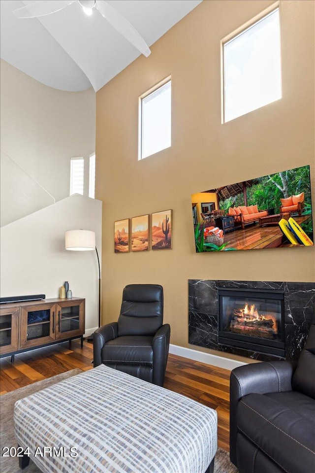 19475 N Grayhawk Dr Unit 1115, Scottsdale, AZ 85255 - living room with high vaulted ceiling, wood finished floors, a glass covered fireplace, ceiling fan, and baseboards