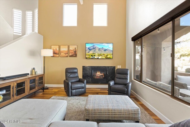 19475 N Grayhawk Dr Unit 1115, Scottsdale, AZ 85255 - living area featuring a premium fireplace, wood finished floors, healthy amount of natural light, baseboards, and a towering ceiling