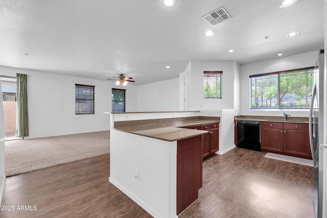 kitchen featuring visible vents, dishwasher, open floor plan, a peninsula, and dark wood finished floors