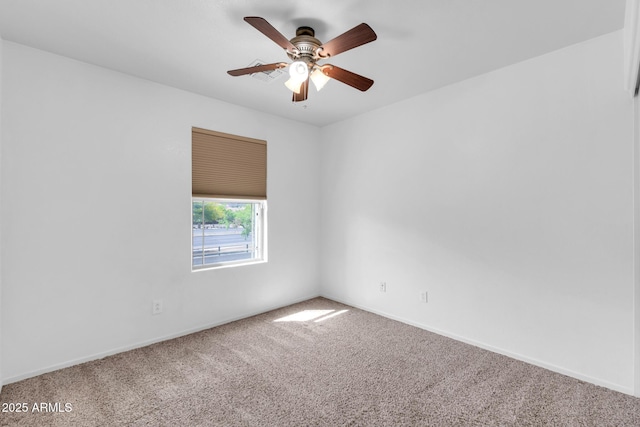 carpeted spare room with baseboards and a ceiling fan