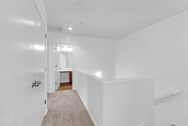 hall featuring carpet flooring, baseboards, and recessed lighting