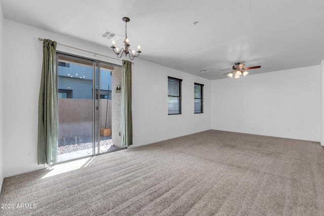 carpeted empty room featuring visible vents, ceiling fan with notable chandelier, and a healthy amount of sunlight