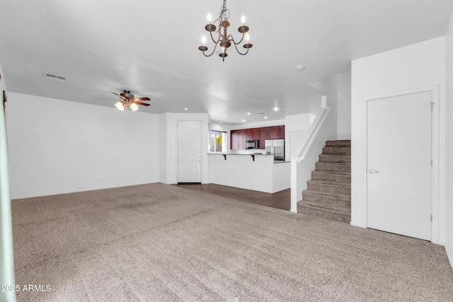 unfurnished living room featuring recessed lighting, visible vents, ceiling fan with notable chandelier, and dark carpet