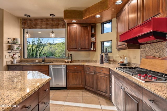 kitchen featuring custom range hood, hanging light fixtures, appliances with stainless steel finishes, and light stone countertops