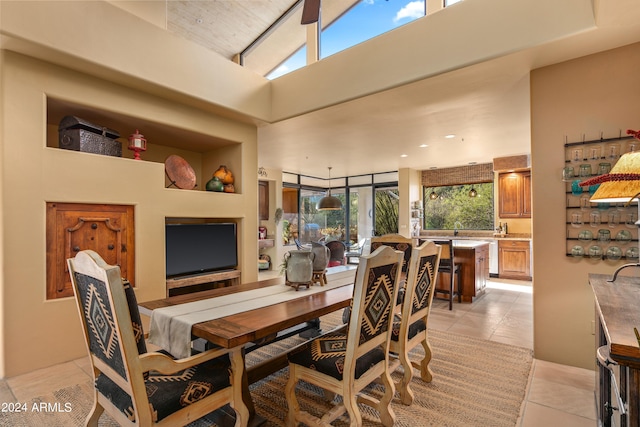 tiled dining space featuring high vaulted ceiling