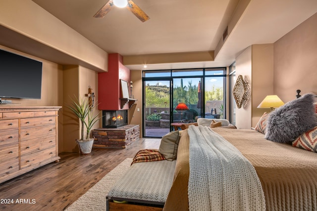 bedroom with access to outside, a fireplace, dark hardwood / wood-style floors, floor to ceiling windows, and ceiling fan