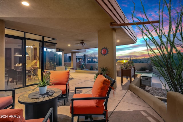 patio terrace at dusk featuring an outdoor living space and ceiling fan