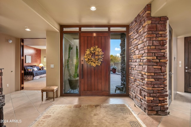 tiled entryway featuring brick wall