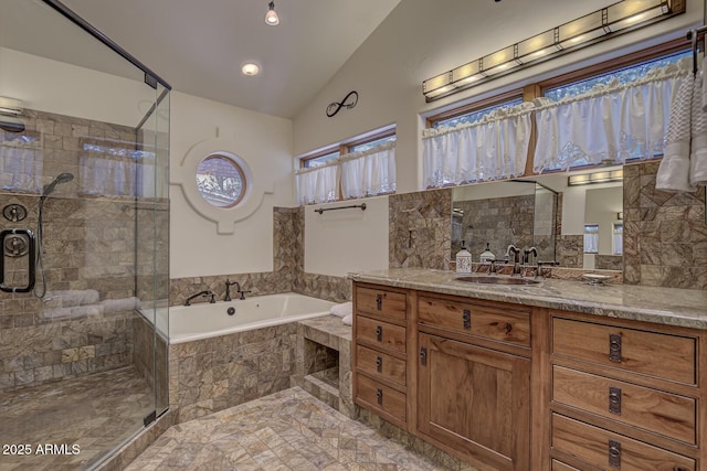 full bath featuring a stall shower, a garden tub, vaulted ceiling, and vanity