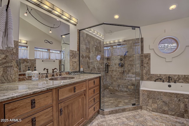 full bathroom featuring vaulted ceiling, a stall shower, a garden tub, and vanity