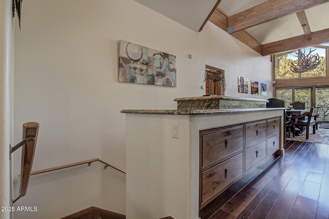 interior space with dark wood finished floors, beamed ceiling, and an upstairs landing