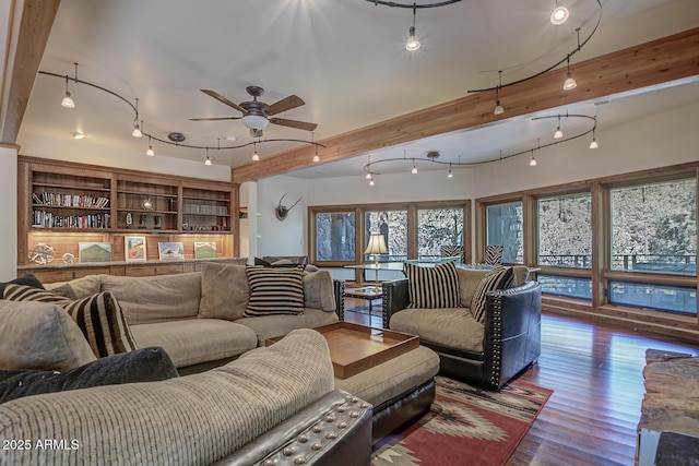 living area with beam ceiling, a ceiling fan, and wood finished floors