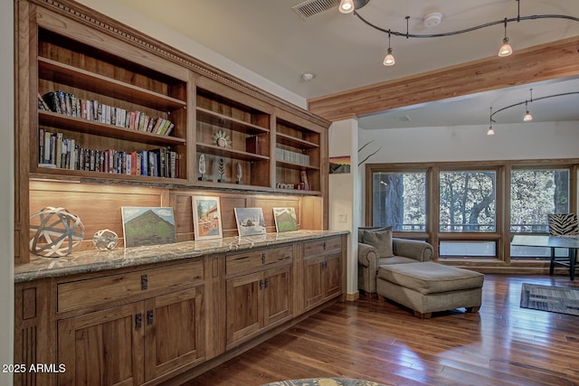 living area with beamed ceiling, dark wood finished floors, visible vents, and a healthy amount of sunlight