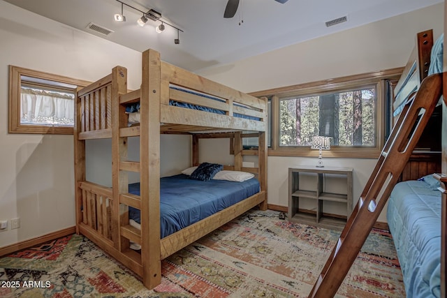 bedroom featuring baseboards, visible vents, track lighting, and wood finished floors