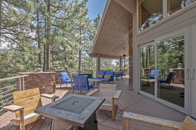 deck with an outdoor living space with a fire pit