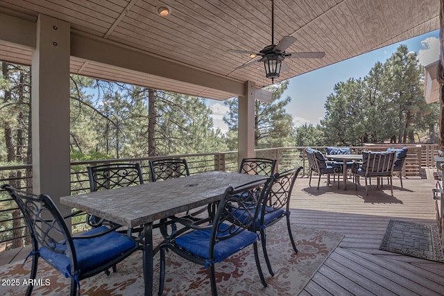 wooden deck featuring outdoor dining area and a ceiling fan