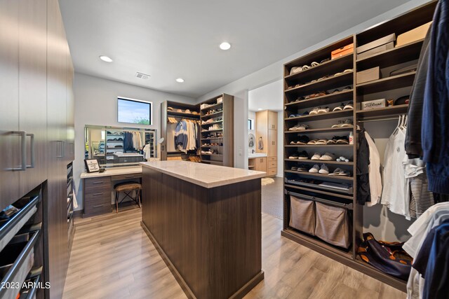 walk in closet with light hardwood / wood-style flooring