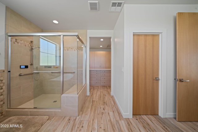 bathroom featuring hardwood / wood-style flooring and a shower with shower door