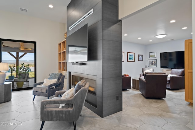 living room featuring light tile patterned flooring and a fireplace