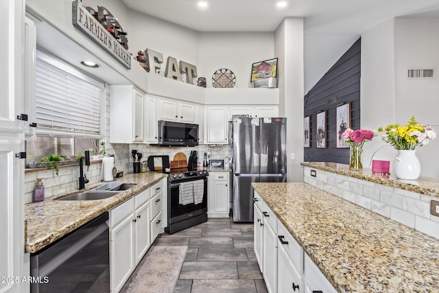 kitchen featuring stainless steel appliances, sink, white cabinets, and decorative backsplash