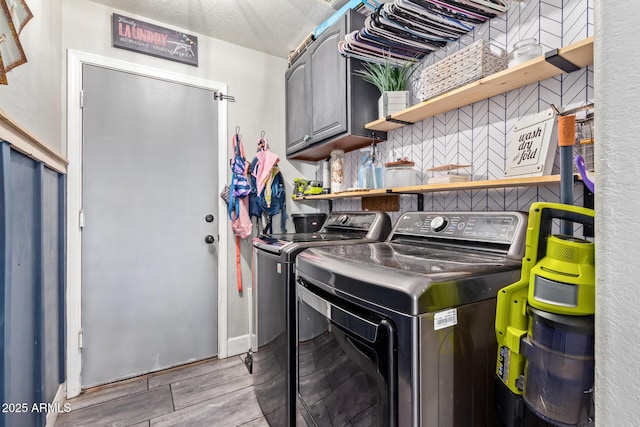 clothes washing area with cabinets and independent washer and dryer