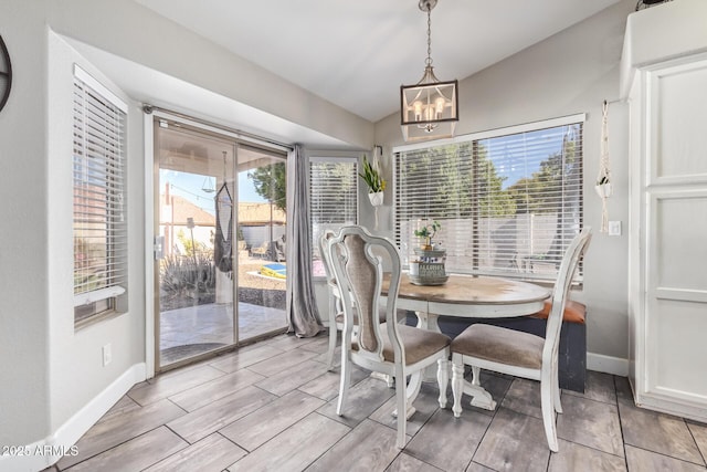 dining room with an inviting chandelier, plenty of natural light, and lofted ceiling